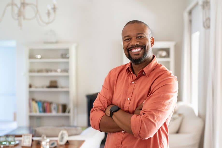 a man smiles with his arm crossed