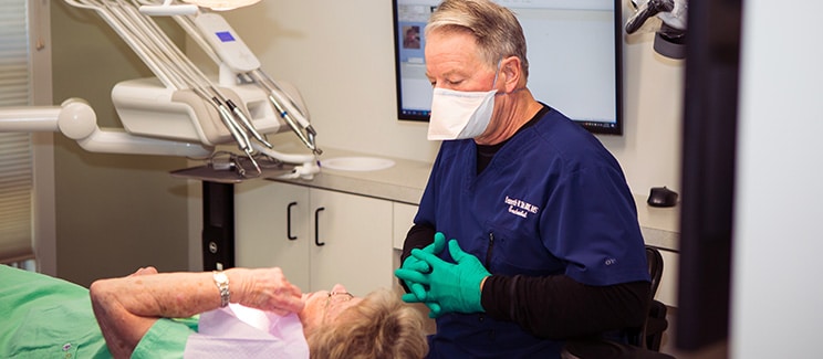 doctor speaking with patient in dental chair